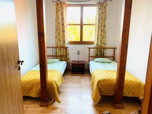 two twin beds in a room with a window at Domjana Lubiatowo in Lubiatowo