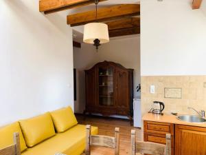 a living room with a yellow couch in a kitchen at Domjana Lubiatowo in Lubiatowo