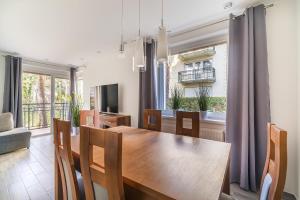 a dining room with a wooden table and a window at Apartament Dominika in Jurata
