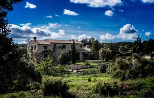 una vieja casa de piedra en medio de un campo en Mas de l'Arlequi, en Rojals