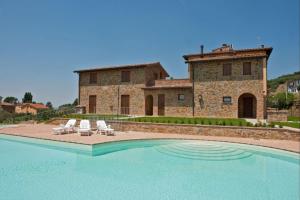 una villa con piscina di fronte a un edificio di Il Borgo sul Lago a Monte del Lago