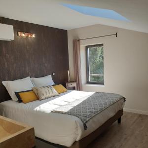 a bedroom with a large white bed with a window at Mas de Reilhanette in Montbrun-les-Bains