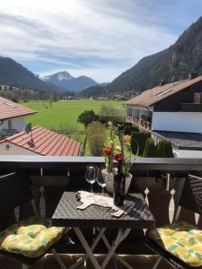 - une table avec des verres à vin et une vue sur un champ dans l'établissement Anneliese, à Pfronten