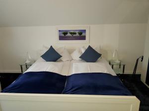 a large bed with blue and white sheets and pillows at Villa zur schönen Aussicht in Bad Salzuflen