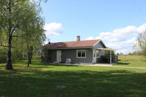 een klein huis in een veld met een groene tuin bij Kärraton Stugor in Åhus