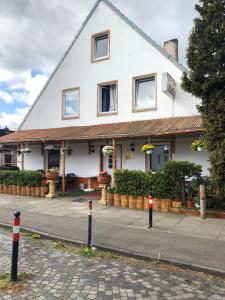 a white building with red and white poles in front of it at Hotel Riede in Bremen