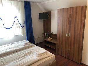 a bedroom with a bed and a cabinet and a window at Hotel Riede in Bremen