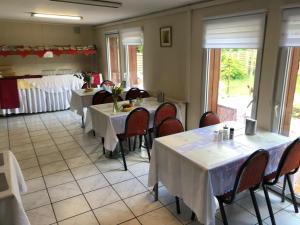 a restaurant with tables and chairs with white tablecloths at Hotel Riede in Bremen