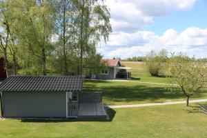 un pequeño cobertizo en un patio con una casa en Kärraton Stugor, en Åhus