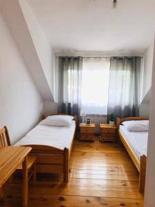 two beds in a room with a window at Marina Niedźwiedzi Róg in Ruciane-Nida