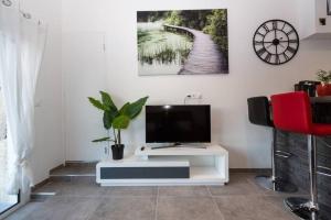 sala de estar con TV en una mesa blanca en Petit Cocon Cosy avec Terrasse, en Gignac-la-Nerthe