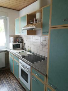 a kitchen with blue cabinets and a stove top oven at Ländliche Erholung 1 in Heideland