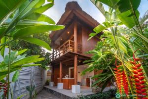 una casa con un montón de plantas delante de ella en Villa Kamboja - Intimate Luxury Lovina Beach Villa, en Banjar