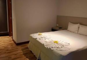 Un dormitorio con una cama con dos flores. en Casa Cavalo Marinho - Superconfortável! Perto de tudo, longe do tumulto., en Arraial d'Ajuda