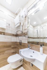 a bathroom with a white sink and a toilet at Hotel Doris in Oborniki