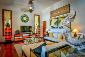 sala de estar con sofá y TV en Villa Kamboja - Intimate Luxury Lovina Beach Villa, en Banjar