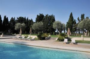 - une piscine avec des chaises longues et des parasols dans l'établissement Domaine du Grand Malherbes, à Aimargues