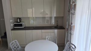 a small kitchen with a table and a microwave at Apartament Czarna Góra B11 in Sienna