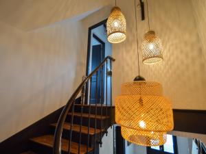 a hallway with three lights and a staircase at La Paresse en Ville in Bayeux