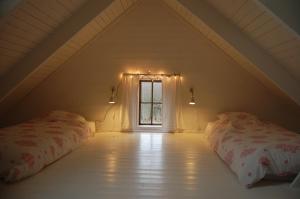 a attic room with two beds and a window at Lillstugan in Torestorp
