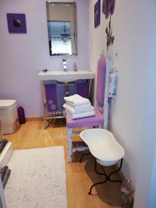 a bathroom with a sink and a chair and a mirror at Quinta Nova Guest Room in Odivelas