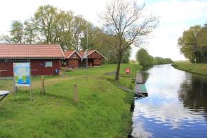 a river with houses and a stop sign on the side at Friedeburga in Friedeburg