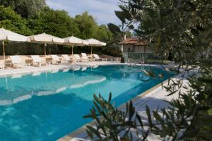 a swimming pool with chairs and umbrellas at Relais Fra' Lorenzo in Verona