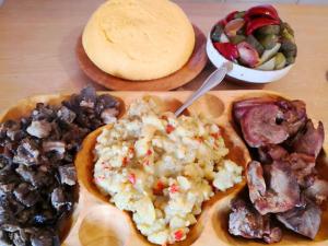 フンダタにあるPensiunea Ederaのテーブルの上に様々な種類の食べ物を並べたテーブル