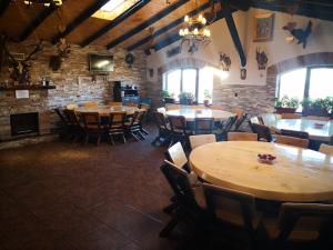 フンダタにあるPensiunea Ederaの広い客室で、レストラン内のテーブルと椅子が備わります。
