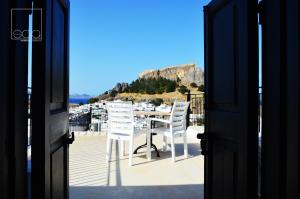 an open door to a balcony with a table and chairs at Sala Traditional Experience. Lindos in Lindos