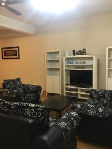 ein Wohnzimmer mit 2 Sofas und einem Flachbild-TV in der Unterkunft Aziym Homestay@Bandar Baru Bangi in Kampong Tangkas