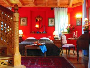 czerwona sypialnia z łóżkiem i stołem w obiekcie Zamek Korzkiew w mieście Korzkiew