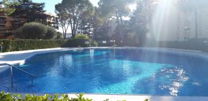 una gran piscina con agua azul en un patio en Charmant appartement dans résidence avec piscine en Mandelieu-la-Napoule