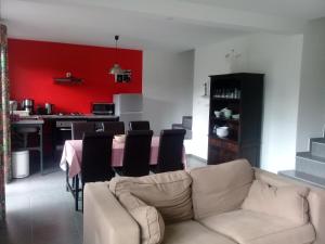- un salon avec un canapé et un mur rouge dans l'établissement Les Canneliers, à Saint-Leu