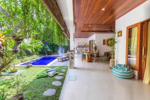an open living room with a pool in a house at MasBro ART Villas in Seminyak