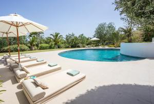 - Piscina con tumbonas y sombrilla en Imagine Your Family Renting This Luxury Villa, Ibiza Villa 1008, en Sant Josep de sa Talaia