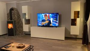 a flat screen tv sitting on a white stand in a living room at Stadtvilla Intzeplatz - Apartment Borkum in Remscheid