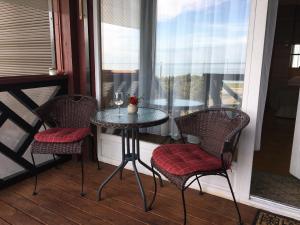 - une table et des chaises sur une terrasse couverte avec une fenêtre dans l'établissement Curonian Coast studio, à Nido