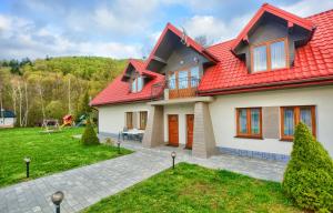 a house with a red roof at APARTAMENTY SPA & RESORT BUKOWIEC in Polańczyk