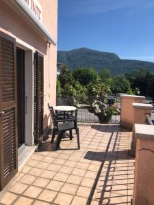 eine Bank auf einer Terrasse mit einem Tisch in der Unterkunft Ristorante Campagna in Cugnasco