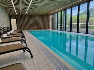 a swimming pool with lounge chairs and windows at Výhledy Stolová in Čeladná