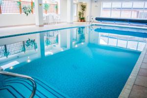 a swimming pool with blue water in a building at Beachlands Hotel in Weston-super-Mare