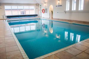 a swimming pool with blue water in a building at Beachlands Hotel in Weston-super-Mare