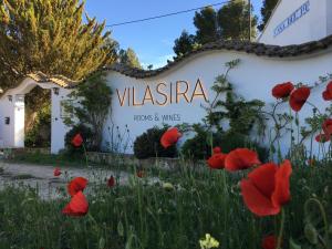 a sign with red poppies in front of a building at VILASIRA ( Rooms & Wines ) in Los Cojos