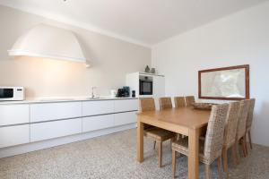 a kitchen with a wooden table and some chairs at Villa Paula in Sveta Marina