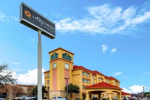 a building with a clock tower with a street sign at La Quinta by Wyndham DFW Airport West - Bedford in Bedford