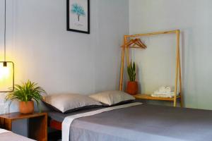 ein Schlafzimmer mit einem Bett, einem Spiegel und Pflanzen in der Unterkunft Quynh's Homestay in Tuy Hoa