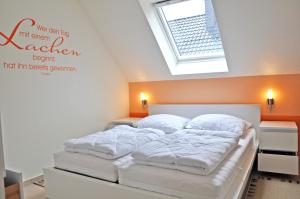 um quarto com uma cama branca e uma clarabóia em Ferienhaus Müritzbrise / OG-Appartement em Marienfelde