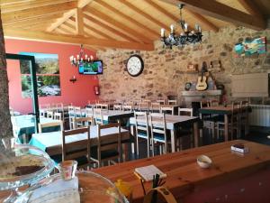 un restaurante con mesas y sillas y un reloj en la pared en Hosteria Calixtino en Palas de Rei 