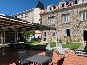 een patio met stoelen en een tafel voor een gebouw bij Guest House Libertas in Dubrovnik